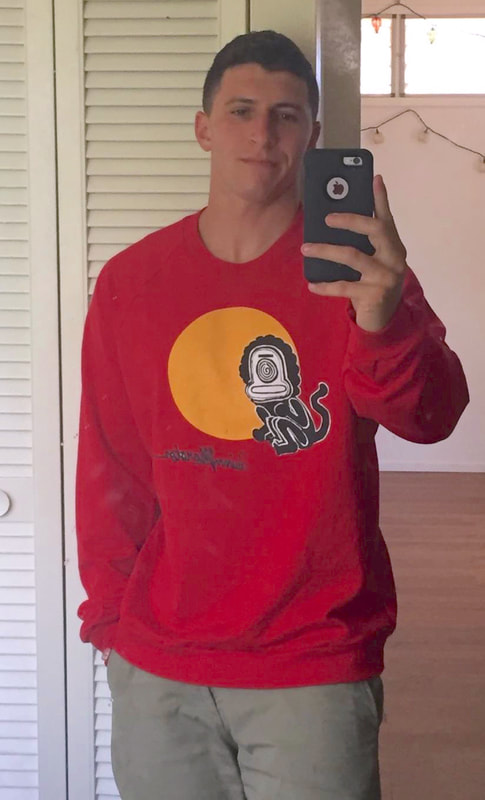 Red graphic sweatshirt with funny little sun monkey imagery from painting by Quinn Marston. Artist signature on front.