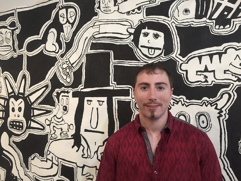 Multidimensional artist, Quinn Marston in front of one of his large, graphic, contemporary, black and white acrylic paintings