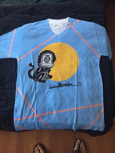 Graphic blue, orange, yellow t-shirt with sun monkey imagery from painting by Quinn Marston. Artist signature on front.